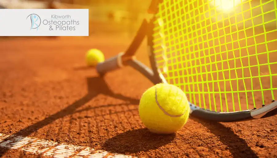 Tennis racket and balls on a clay court